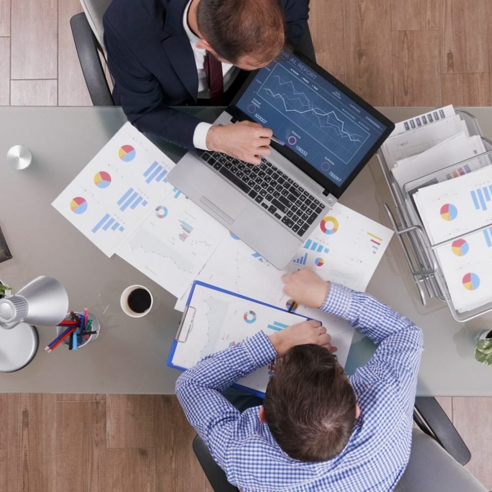 Top view of businessmen analyzing management statistics while working at company investments